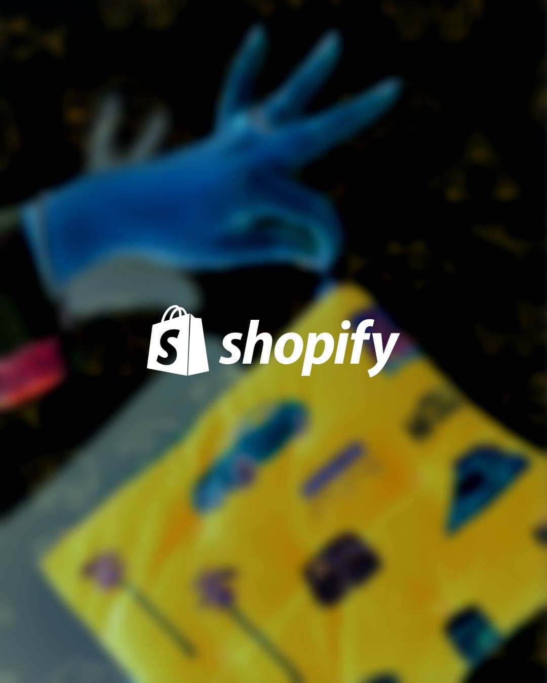Shopify logo centered over a dark, blurred background with a blue hand and yellow shapes.